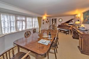 a dining room with wooden tables and a piano at Finest Retreats - Bakers Mews Cottage in Kimbolton