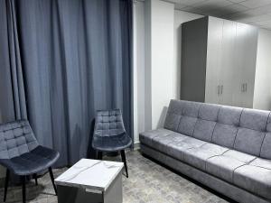 a living room with a couch and two chairs at Downtown Inn Madaba in Madaba