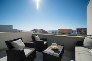- un balcon avec des chaises et une corbeille de fruits sur une table dans l'établissement Villa Flavia and Alba - Private Heated Pool, à Novalja