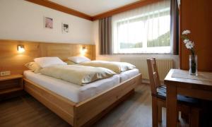 a bedroom with a large bed with a window at Appartementhaus Daniel in Saalbach-Hinterglemm