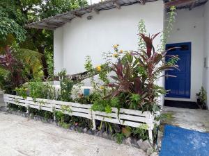 a garden in front of a house with a blue door at La Due Thulusdhoo in Thulusdhoo