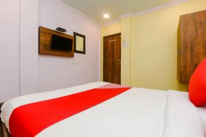 a bedroom with a red and white bed in a room at OYO Hotel Stayland Near Juhu Beach in Mumbai