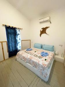 una camera da letto con un letto con un pesce sul muro di La Due Thulusdhoo a Thulusdhoo