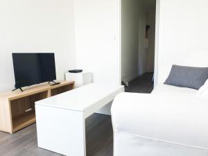 a living room with two beds and a tv at EXIGEHOME-Appart très lumineux aux portes de Paris in Suresnes