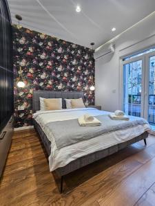 ein Schlafzimmer mit einem großen Bett mit Blumenwand in der Unterkunft City life in Belgrad