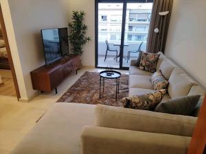 Appartement Parc Mohammedia في المحمدية: غرفة معيشة مع أريكة وتلفزيون