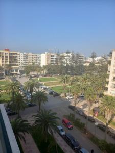 Blick auf einen Parkplatz mit Palmen und Gebäuden in der Unterkunft Appartement Parc Mohammedia in Mohammedia