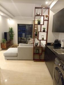 ein Wohnzimmer mit einem Bett und eine Küche in der Unterkunft Appartement Parc Mohammedia in Mohammedia