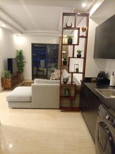 Appartement Parc Mohammedia في المحمدية: غرفة معيشة مع سرير ومطبخ