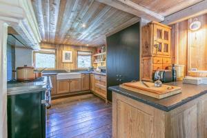 a large kitchen with wooden walls and wooden floors at Le Chalet à Val d'Isère in Le Joseray