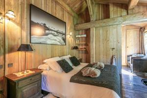 1 dormitorio con 1 cama en una habitación con paredes de madera en Le Chalet à Val d'Isère, en Le Joseray