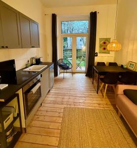a kitchen and living room with a table and a counter at FeelsLikeHome - Stylische und zentrale Altbauwohnung mit Terrasse&Garten in Bochum
