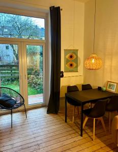 een eetkamer met een tafel en stoelen en een raam bij FeelsLikeHome - Stylische und zentrale Altbauwohnung mit Terrasse&Garten in Bochum