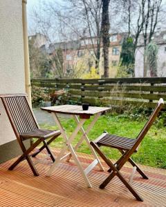 ボーフムにあるFeelsLikeHome - Stylische und zentrale Altbauwohnung mit Terrasse&Gartenのデッキにテーブルと椅子2脚