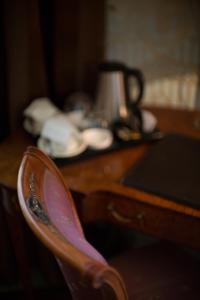 a chair sitting in front of a desk with a tea kettle at Hotel Dei Pittori in Turin