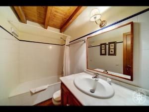 a bathroom with a sink and a toilet and a mirror at PASSARELLS de Alma de Nieve in Gessa