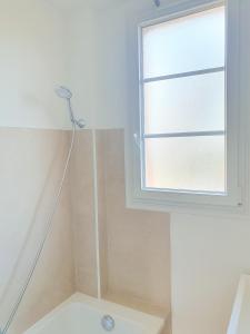 eine Dusche im Bad mit Fenster in der Unterkunft EXIGEHOME-Appart très lumineux aux portes de Paris in Suresnes