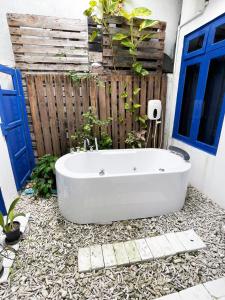 a bath tub sitting in front of a fence at La Due Thulusdhoo in Thulusdhoo