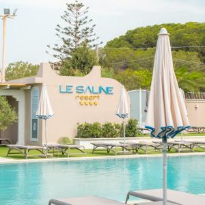 een zwembad met parasols en een resort bij Le Saline Beach Resort in Saline Joniche