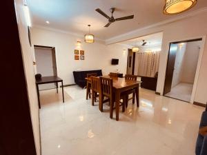 comedor y sala de estar con mesa y sillas en The Canopy House en Bangalore