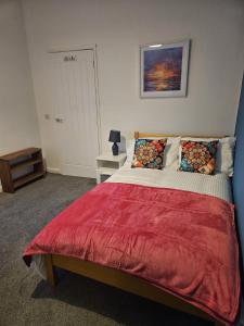 ein Schlafzimmer mit einem großen Bett mit einer roten Decke in der Unterkunft Langley Park House, Durham in Langley Park