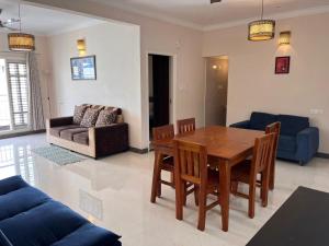 sala de estar con mesa de madera y sofá en The Canopy House en Bangalore
