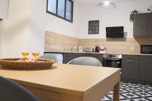 a kitchen with a table with two glasses of wine at Le Cocon Fleuri, proche centre in Mulhouse