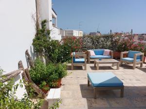 a patio with chairs and tables on a building at MandorleOlio in Polignano a Mare