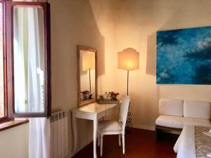 Habitación con escritorio, espejo y silla. en B&B Countryhouse Villa Baciolo, en San Gimignano
