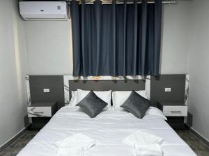 a bedroom with a large white bed with pillows at Downtown Inn Madaba in Madaba