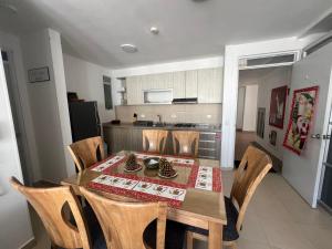 cocina y comedor con mesa y sillas en Hermoso apartamento para descansar en familia en Girardot