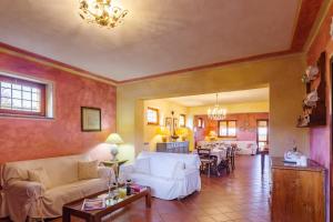 uma sala de estar com sofás brancos e uma sala de jantar em Scappo in Umbria,Mevania em Bevagna