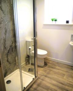 La salle de bains est pourvue d'une douche et de toilettes. dans l'établissement Craigielea Cottage, à Newton Stewart