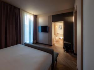 ヴィチェンツァにあるThe Glam Boutique Hotel & Aptのベッドとバスルーム付きのホテルルームです。
