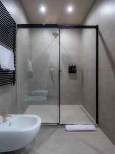 La salle de bains est pourvue d'une douche, d'un lavabo et de toilettes. dans l'établissement The Glam Boutique Hotel & Apt, à Vicence