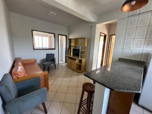 a living room with a couch and a kitchen at Villa Cavaliere in Palhoça
