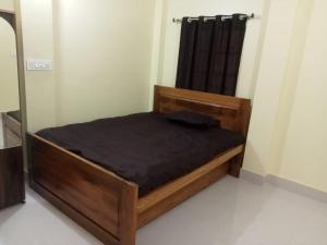 Nidhivan Residency في Navadwīp: غرفة نوم بسرير خشبي في غرفة