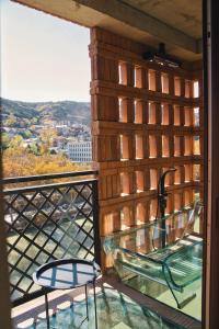 uma varanda com uma mesa de vidro e 2 cadeiras em Sandali Metekhi Boutique Hotel em Tbilisi