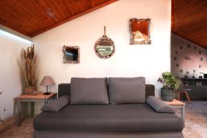 a couch in a living room with mirrors on the wall at Nona's Central House 3bd in Zakynthos