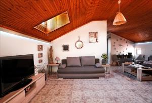 a living room with a couch and a television at Nona's Central House 3bd with a Garden In the City Center By Villa Mana Gers in Zakynthos Town