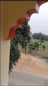 een schilderij van een uitzicht op een veld met bomen bij Nidhivan Residency in Navadwīp