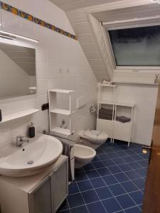 a bathroom with two sinks and a toilet at Gemütliche Wohnung am Waldrand in Thierhaupten