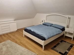 Un dormitorio con una cama con almohadas azules. en Gemütliche Wohnung am Waldrand, en Thierhaupten