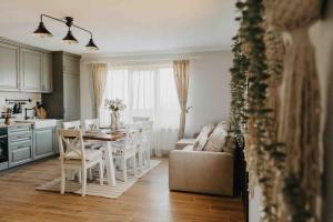 eine Küche und ein Wohnzimmer mit Tisch und Stühlen in der Unterkunft Ammacabin in Sângeorz-Băi