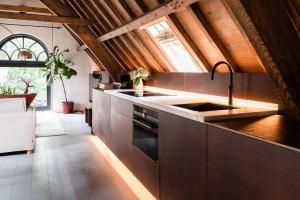 een keuken met bruine kasten en een wastafel bij Landgoed Huis te Jaarsveld 