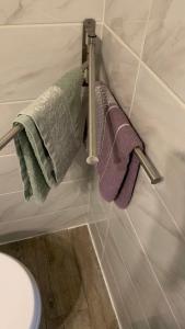 ein Bad mit drei an der Wand hängenden Handtüchern in der Unterkunft Adorable studio 20m2 in Aubervilliers