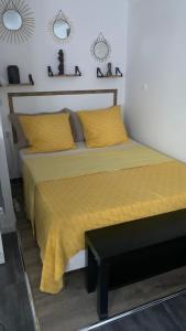 een slaapkamer met een groot bed met gele lakens bij Adorable studio 20m2 in Aubervilliers