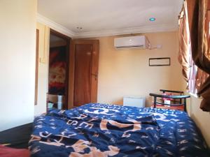 a bedroom with a bed with a blue comforter at One piece kampot in Kampot