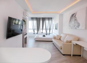 Biały salon z kanapą i telewizorem w obiekcie Sun Apartments w mieście Torremolinos