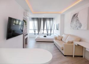 un soggiorno bianco con divano e TV di Sun Apartments a Torremolinos